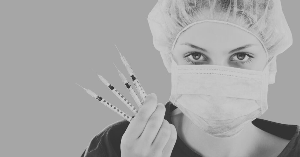 An injector with many syringes while wearing a mask